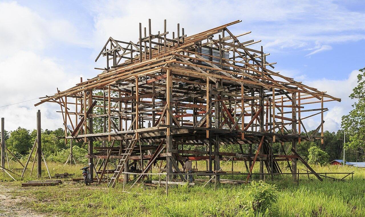 Kg. Salarom, Sapulut, Sabah: A carpenter is working at the frame of a newly built, traditional house in Kg Salarom