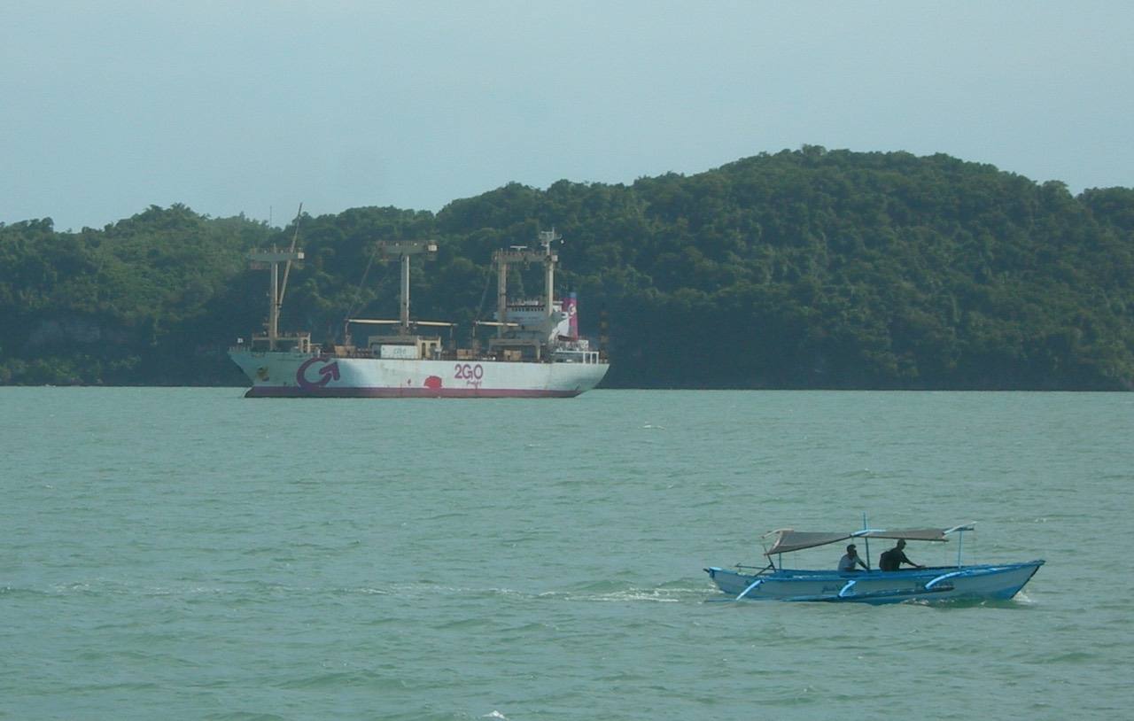 Cargo ship of 2GO Freight, part of the 2GO Group, in Iloilo Strait, the Philippines, with a pump boat.